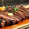 Juicy tomahawk steak sliced and served on a wooden cutting board, with a golden-brown crust, medium-rare center, garnished with rosemary and garlic butter, paired with roasted potatoes and grilled asparagus.