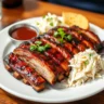 ( Close-up of tender pork ribs cooking on a gas grill, coated in barbecue sauce with charred edges and smoky steam in the background )A plate of perfectly grilled pork ribs served with coleslaw and cornbread, garnished with parsley and a side of barbecue sauce.