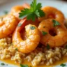 Shrimp St. Charles with creamy Cajun sauce, served over rice, garnished with fresh parsley for a delicious Southern seafood meal.