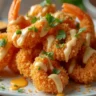 Boom Boom Shrimp coated in crispy panko breadcrumbs with creamy Boom Boom sauce and garnished with cilantro and lime