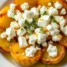 Golden roasted potatoes topped with creamy feta cheese, garnished with fresh herbs and lemon zest