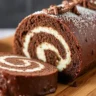 A decadent Triple Chocolate Roll Cake filled with chocolate mousse, topped with a glossy ganache, and rolled to perfection.