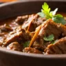 A close-up of Spicy & Aromatic Beef Vindaloo Curry served in a rustic brown dish, with rich textures and true-to-life colors, captured in soft, natural lighting.