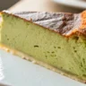 Close-up shot of Vanilla Matcha Basque Cheesecake served in a white dish, showcasing its golden-brown top and creamy green matcha center