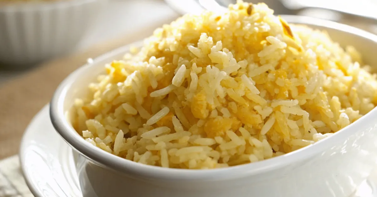 A close-up of Golden Butter Rice served in a white ceramic dish with soft, diffused natural lighting