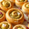 Close-up of perfect pistachio rolls with sweet glaze served in a white dish, with soft, golden-brown rolls and a glossy finish.