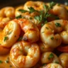 Close-up shot of creamy garlic paprika shrimp served in a white plate with soft, natural lighting.