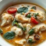 Tuscan Chicken Soup served in a white ceramic bowl with chicken, spinach, and sun-dried tomatoes, captured in soft natural lighting.