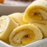 Sweet Mochi Rolls with Banana Filling served in a white ceramic dish, captured in natural light for an authentic, realistic food photography look.