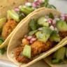 Close-up image of Crunchy Chicken Tacos with Poblano and Avocado Jalapeño Salsa served in a white plate with natural lighting