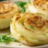 Oven Roasted Garlic Cabbage Steaks served on a white plate with golden crispy edges and garlic herb topping