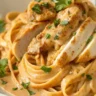 Close-up of Creamy Cowboy Butter Chicken Linguine with seared chicken, creamy sauce, and fresh parsley served in a white plate