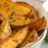 Close-up of golden crispy Seasoned Oven Baked Potato Wedges on a white plate with dip
