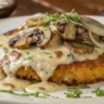 Mozzarella Rösti with Onion and Mushroom Cream Sauce served on a white plate, topped with creamy mushroom-onion sauce and garnished with thyme