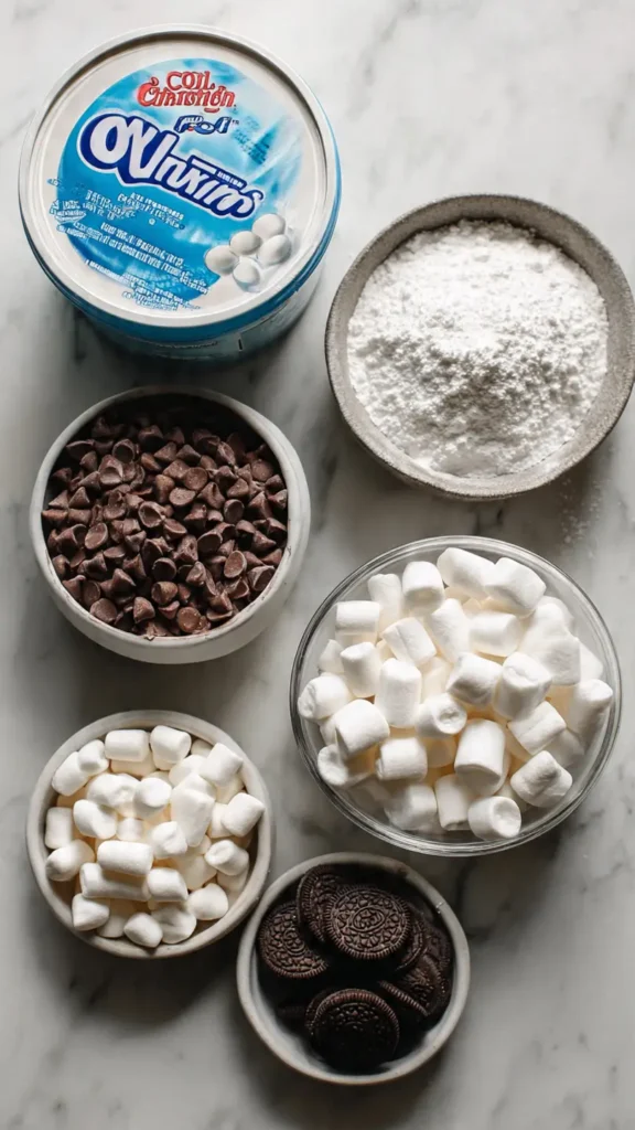 Cool Whip candy ingredients including Cool Whip container, chocolate chips, and powdered sugar on white counter