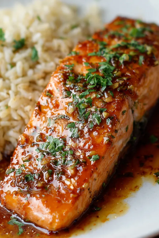 Glazed Texas Roadhouse salmon fillet with caramelized brown sugar coating on white plate