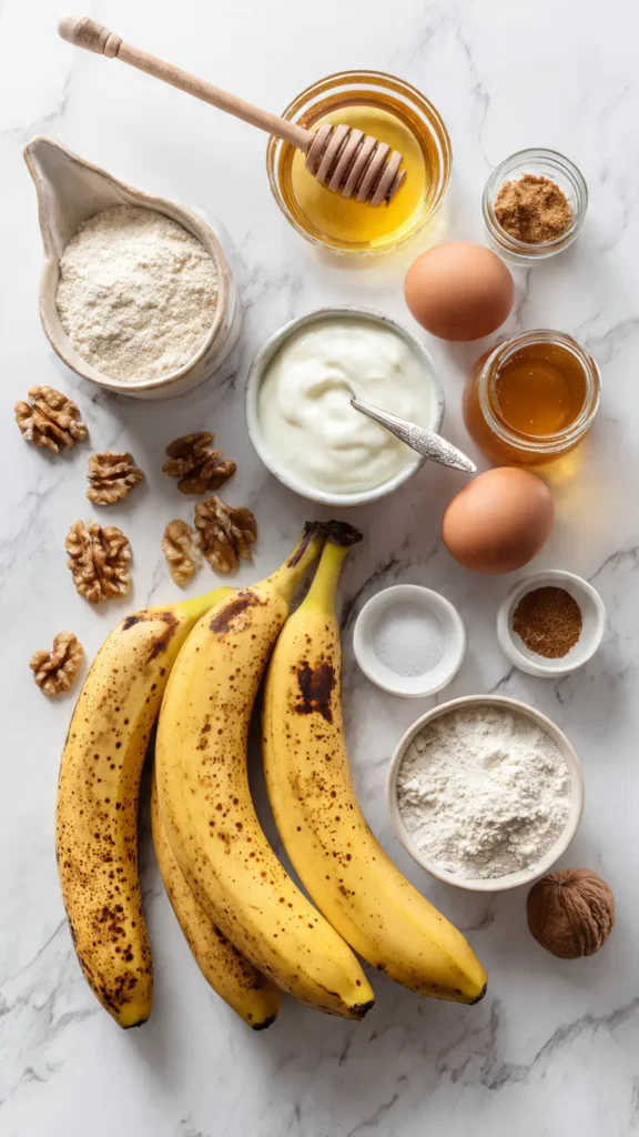 Complete ingredient layout for making healthy banana cake with yogurt: overripe bananas, Greek yogurt, honey, eggs, whole wheat flour, and warming spices