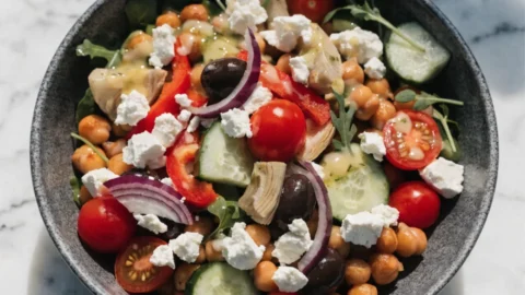 Colorful Mediterranean chickpea bowl with roasted chickpeas, fresh vegetables, feta cheese, and lemon herb dressing - a 380-calorie weight loss meal packed with protein and fiber