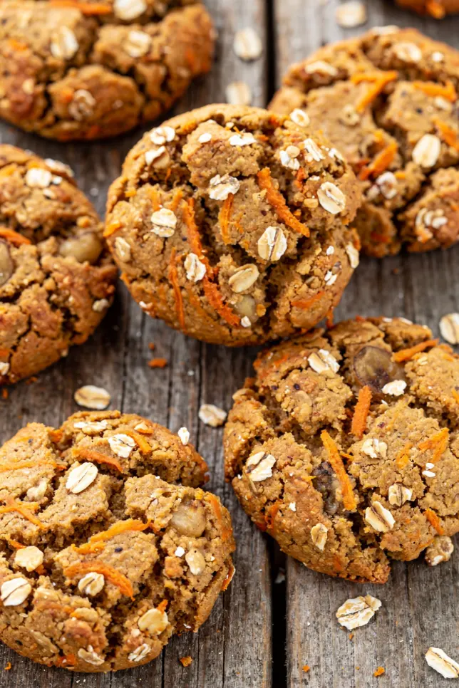 Stack of baked carrot, oat and banana cookies with one cookie broken in half showing the soft interior