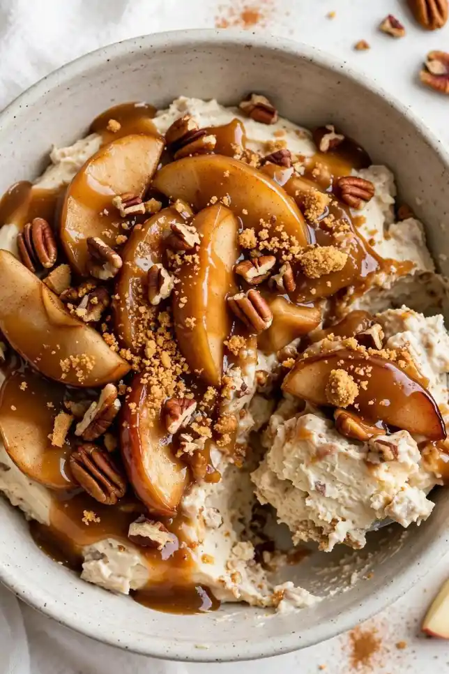 Protein caramel apple cheesecake bowl topped with cinnamon apples, caramel sauce, graham crumbs and pecans